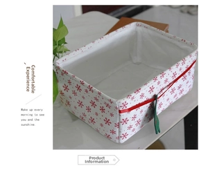 Detail of a foldable Oxford cloth storage basket with red snowflake patterns and green tag