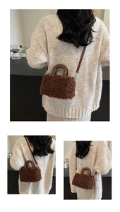 Detailed view of brown plush boston bag with shoulder strap and handle on a cafe counter