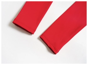 Vue macro des poignets à double surpiqûre sur un t-shirt de yoga rouge en maille douce