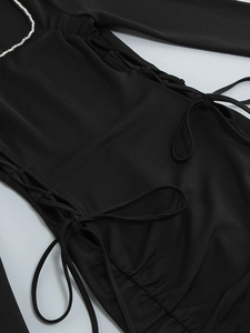 Detail of black square neck dress with rhinestone trim and side drawstring lacing
