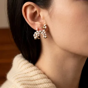 Vintage gold dog stud earrings with white pearls on a model for an elegant look