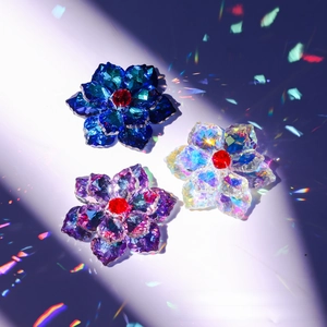 Detailed macro of handmade crystal maple leaf pendants with vibrant rainbow light refraction