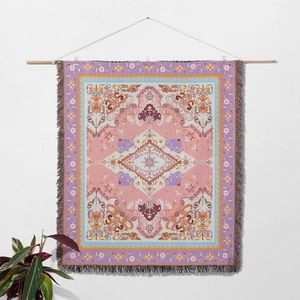 Close-up of bohemian picnic blanket with fringe edges and pink geometric patterns