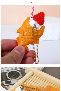 Detail of simulated Taiyaki keychain with cream, strawberry, and gold bead chain