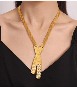 Close-up of 18K gold plated V-shaped woven necklace with crystal pendant on a model