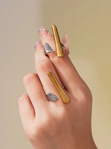 Detail showing minimalist gold bar and silver geometric open rings on model hand