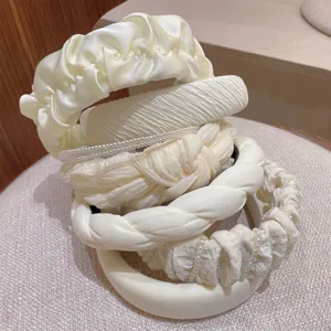 Collection of cream pearl fabric headbands featuring pleated bows and knotted designs