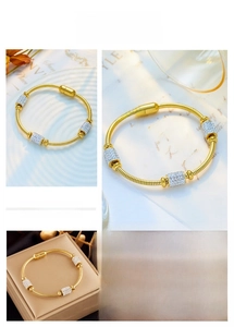 Detail of gold snake chain bracelet featuring three pavé zircon charms and magnetic clasp