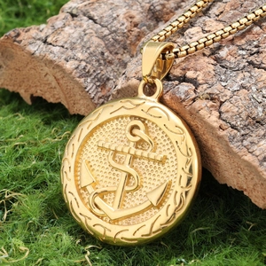 Punk vintage gold coin necklace with anchor pendant on square chain over mossy wood