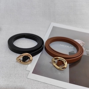 Detailed macro view of black and brown leather belts with irregular gold metal buckles