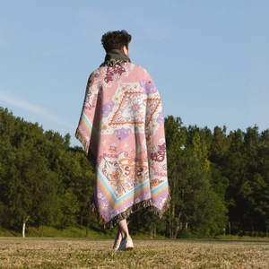 Close-up of bohemian knit camping blanket with colorful jacquard patterns and tassels
