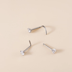 Detailed macro view of G23 titanium nose studs with clear cubic zirconia in three styles