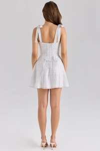 Back view of polka dot chiffon dress featuring tie straps and lace-up open back detail