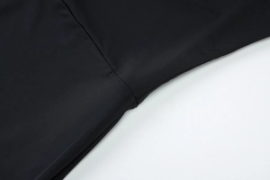 Gros plan sur la texture du tissu noir lisse et couture de qualité sur la combinaison
