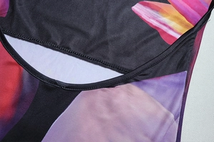 Detail shot of black floral dress featuring vibrant print and precision stitching