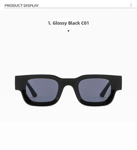 Detail view of shiny black square frame sunglasses with metal hinge and grey lenses