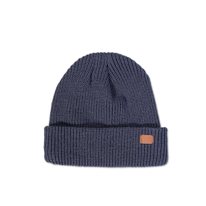 Detailed view of the rib-knit texture and brown leather patch on the navy winter beanie