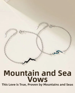 Detail of silver couple bracelets featuring mountain and wave pendants with blue accents