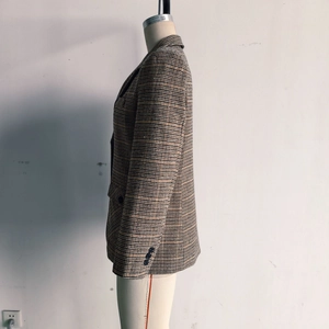 Detailansicht eines braunen Damen-Hahnentritt-Blazers mit Ärmelknöpfen und gewebter Textur