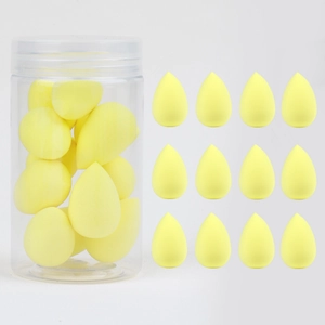 Detail of 12 yellow teardrop makeup sponges with a transparent storage jar