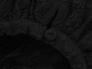 Détails de la dentelle noire raffinée avec des boutons recouverts de tissu assortis