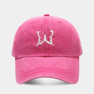 Macro detail of the white butterfly embroidery on rose pink washed cotton baseball cap