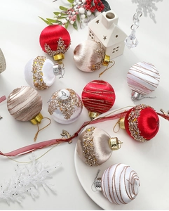 Detailed view of red and champagne Christmas ball ornaments with intricate embroidery textures