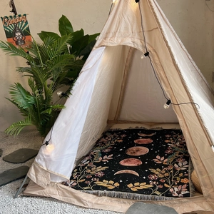 Cozy indoor camping setup featuring a moon phase printed rug inside a pyramid tent