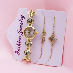 Detailed view of women's gold quartz watch with matching heart and clover bracelets