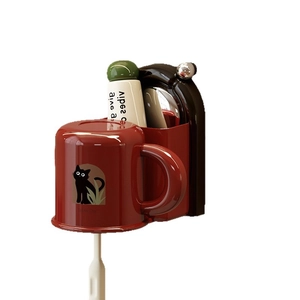 Wall-mounted suction cup toothbrush holder with red rinsing cup and Lucky Day cat design
