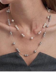 Close-up of double-layered pearl necklace with white and gray pearls on silver chain