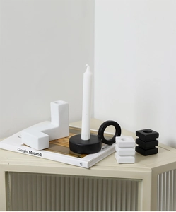 Minimalist black and white ceramic candle holder with a ring base in a Nordic setting