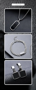 Three-piece stainless steel jewelry set with black enamel pendants on textured background