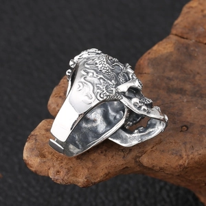 Détail macro d'une bague tête de mort vintage avec gravures de dragon en relief