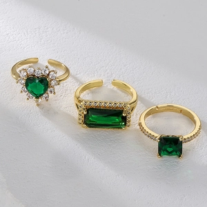 Three-piece gold adjustable ring set featuring emerald green cubic zirconia stones