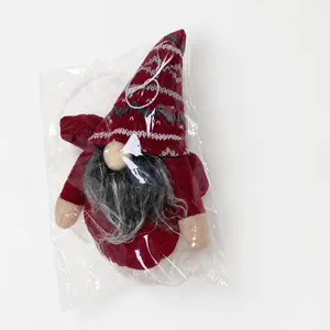 Miniature Christmas forest gnome doll in red and gray being weighed on a scale