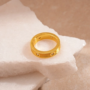 Detail of vintage golden ring with brushed texture and sparkling round cubic zirconia