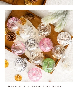 Close-up of decorative Christmas balls with glitter snowflake patterns in a wooden tray