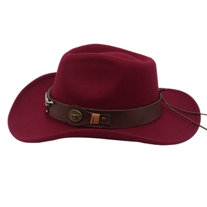 Detail of burgundy felt cowboy hat featuring brown leather band and metallic bull head logo