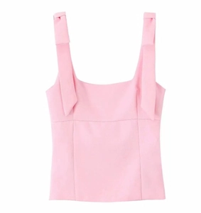 Detail of pink sleeveless top featuring chic shoulder bows and smooth knit fabric