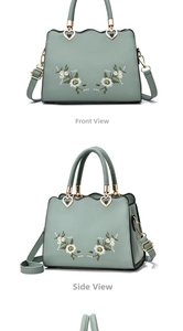 Detail of sage green handbag with daisy embroidery and heart-shaped gold hardware