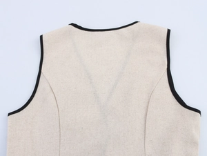 Dettaglio del retro di un abito in lino beige senza maniche con bordi neri e trama fine