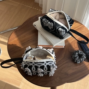 Detail view of black canvas pouches with white butterfly embroidery and tassel fringe decor