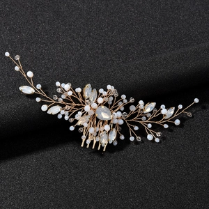 Detailed macro view of bridal hair comb featuring emerald green crystals and gold wire work