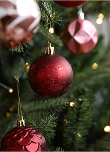 Macro detail of pink and red Christmas balls with glitter patterns on a tree