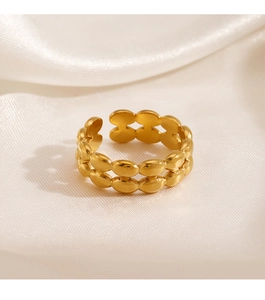 Detail of double-row oval gold plated stainless steel ring on silk background