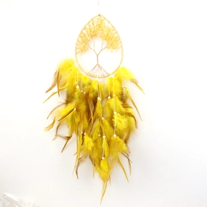 Detailed view of yellow dream catcher with golden tree of life and soft hanging feathers