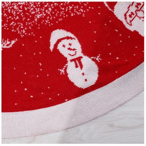 Macro shot of red knitted Christmas tree skirt with white snowman and snowflake pattern