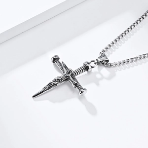 Macro shot of silver stainless steel cross sword pendant with detailed Jesus carving