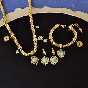 Golden jewelry set with turquoise four-leaf clover, sun, and tree of life pendants